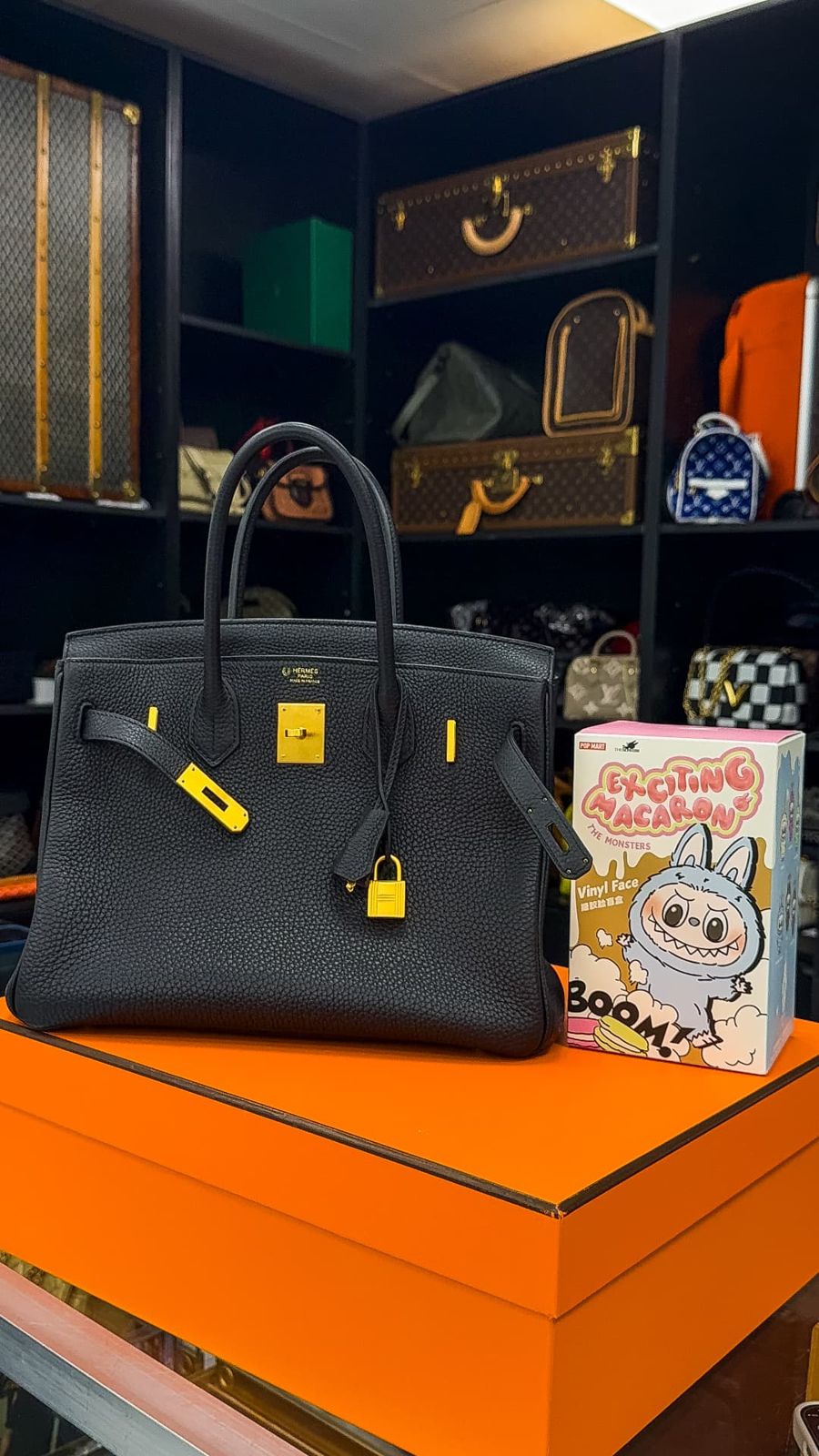 Hermès Birkin 30 in black Togo leather with gold hardware on an orange box