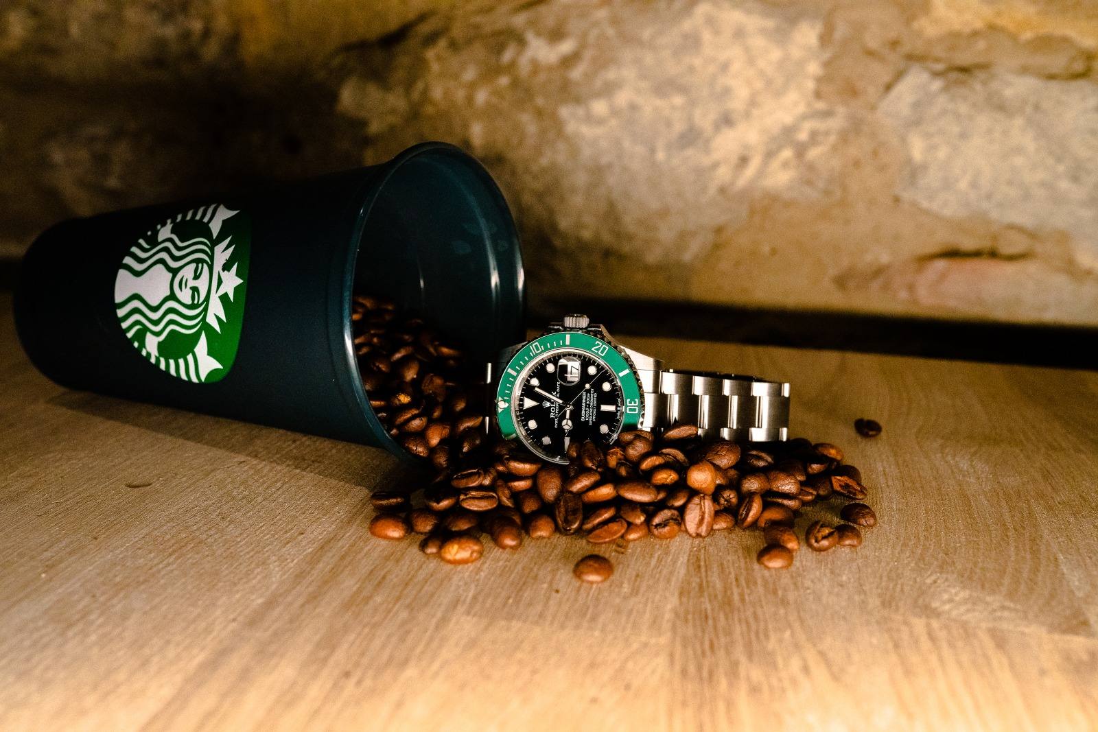 Rolex Submariner with green bezel resting on spilled coffee beans
