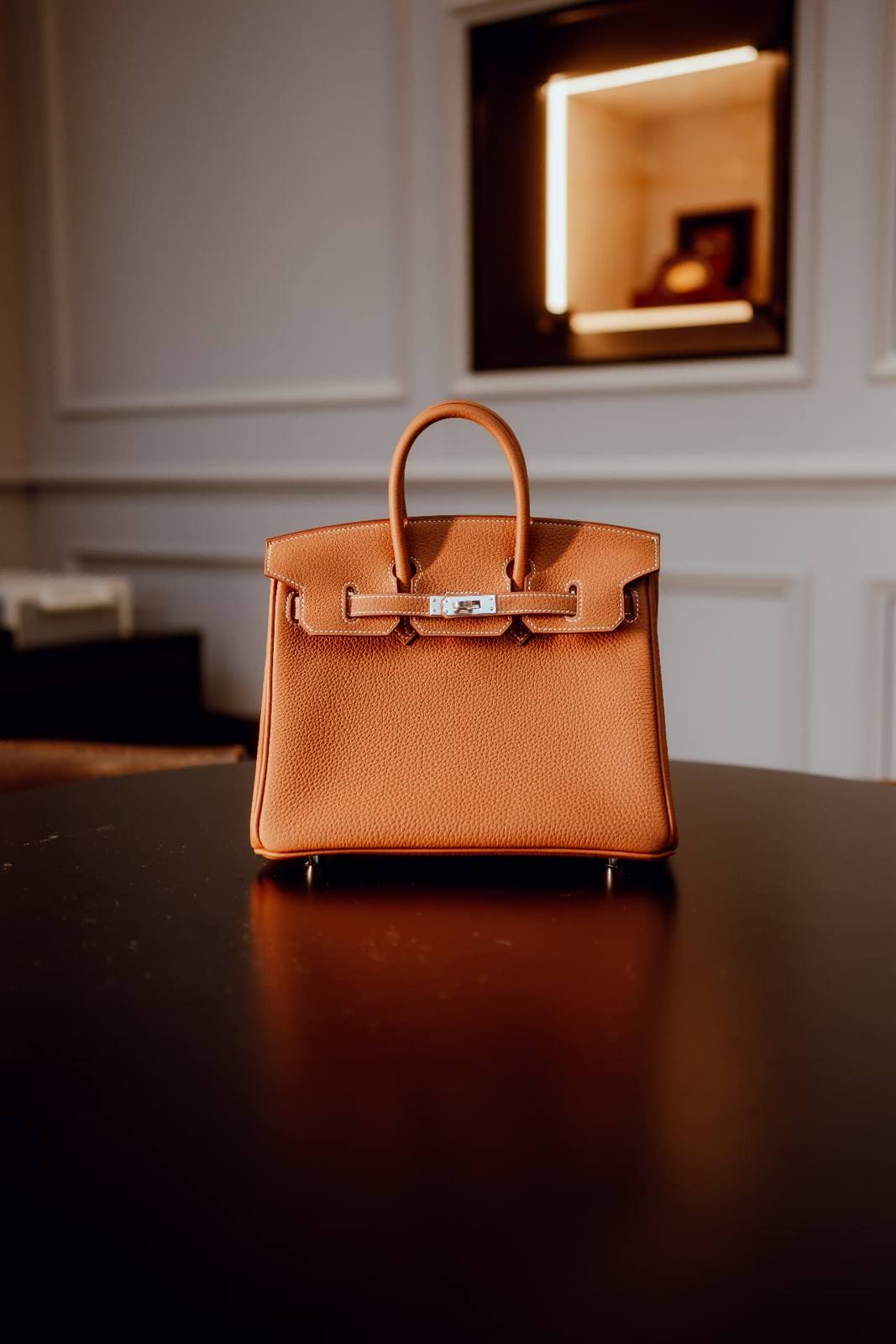 Hermès Birkin 25 in Gold Togo leather centred on a dark round table